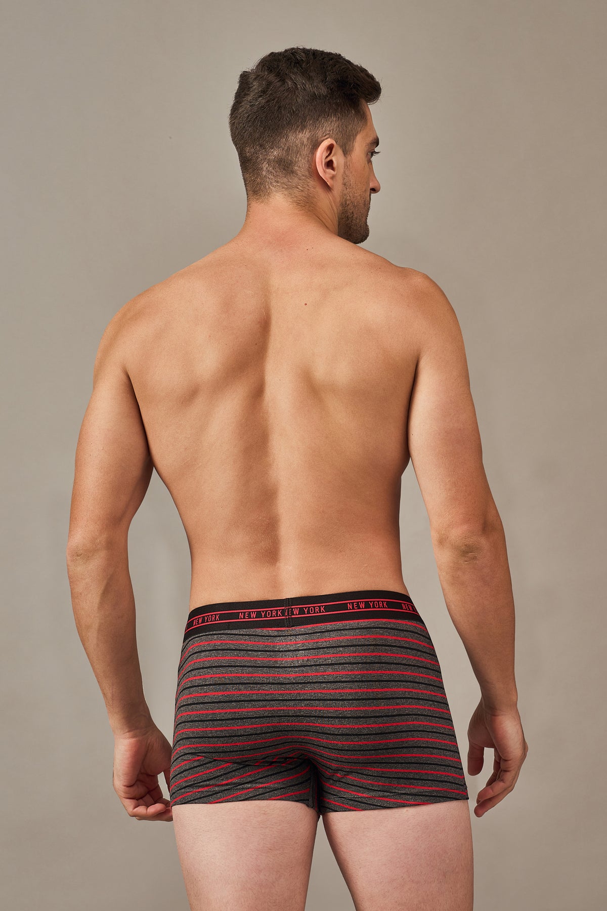 Back view of men's black and red horizontal striped cotton trunks with a stay-put fit