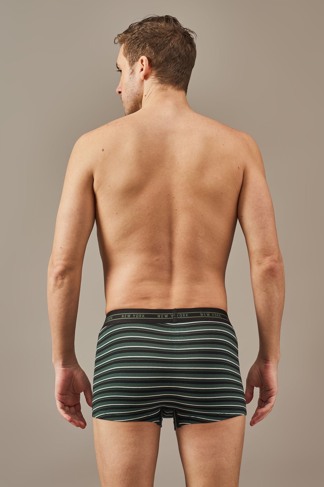 Back view of men's dark green striped cotton trunks with stretch fabric and full coverage