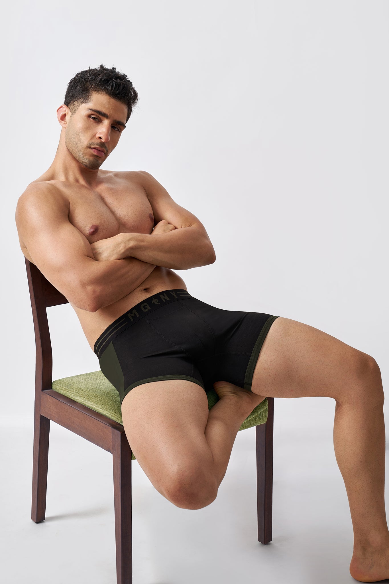 Man wearing Macho Genie black stretch cotton boxer briefs in a relaxed seated pose