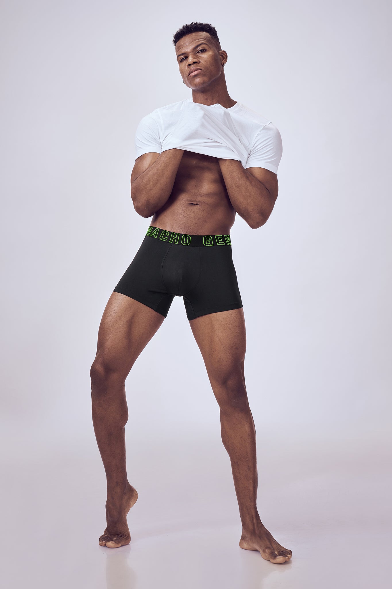 Macho Genie men's performance black boxer trunks with a supportive stretch waistband and fitted design shown on a male model