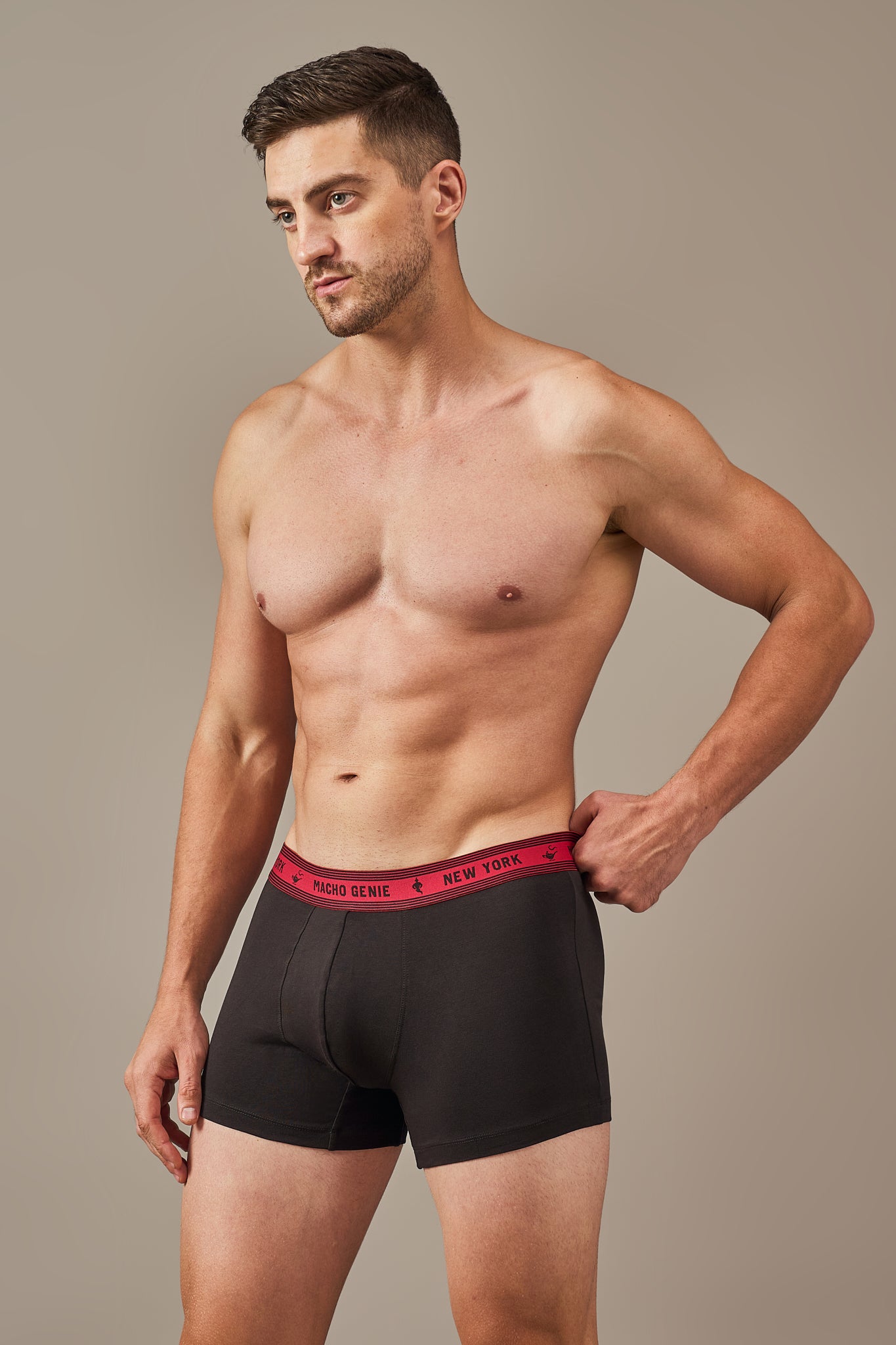 Macho Genie Bold Impressions men's cotton trunks shown from a close-up view with a contoured pouch, 3-inch inseam, and supportive stretch waistband in Black