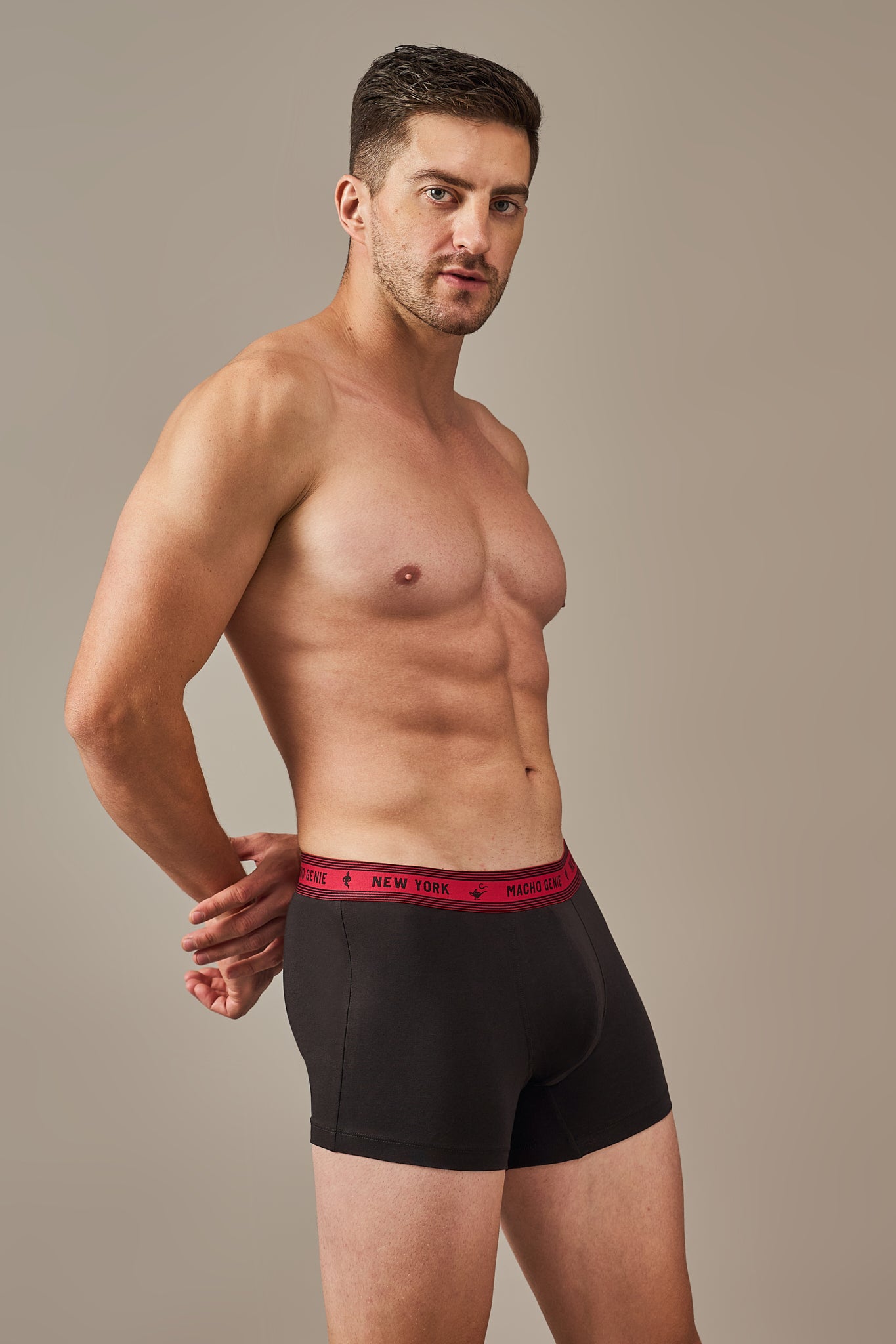 Macho Genie Bold Impressions men's cotton black colored trunks shown from the side with a streamlined fit, contoured pouch, 3-inch inseam, and flexible waistband